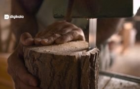 دست یک نجار در حال کار روی چوب در یک کارگاه نجاری