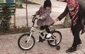دختربچه ای درحال دوچرخه سواری در پارک