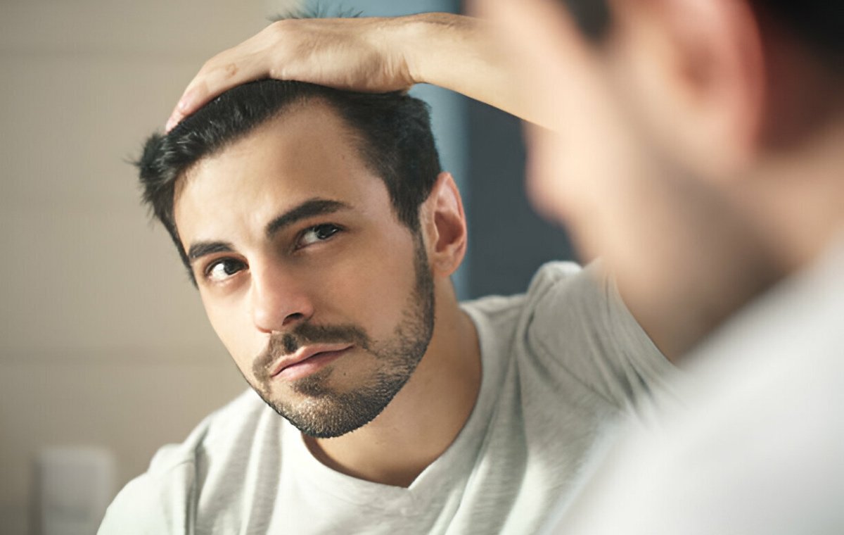 یک مرد جوان که در آینه به موهایش نگاه می‌کند