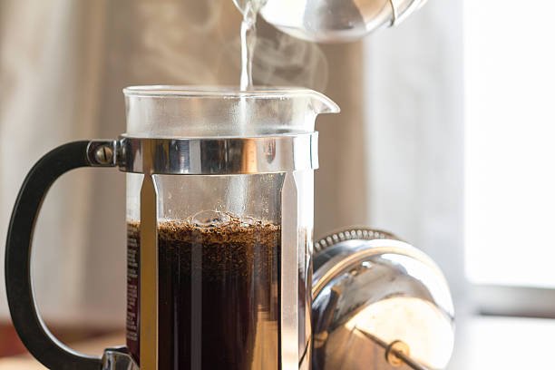 Coffee brewing in a French press in warm morning light;