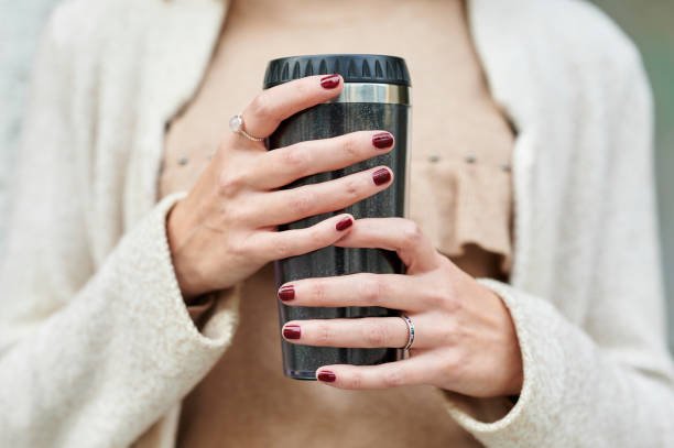 Close-up of woman's hands holding a reusable cup