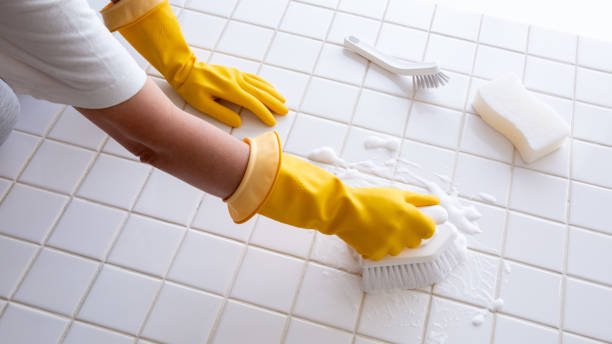 Hands of a person cleaning tiles